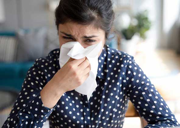 Woman with runny nose and a tissue